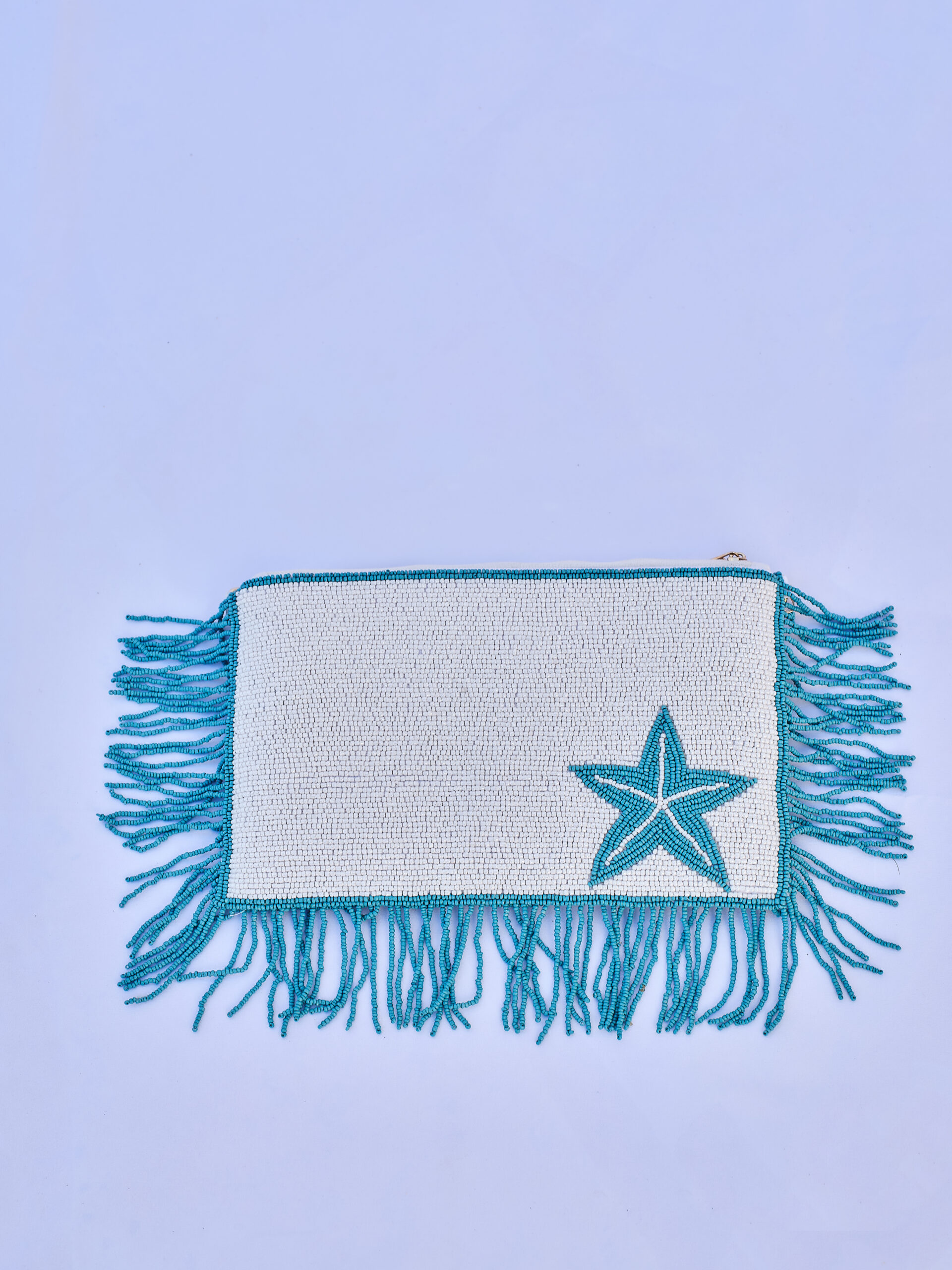 Bolso de mano confeccionado a mano con cuentas decorativas, flecos y cadena metálica.